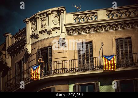 Barcellona, Spagna. 11 Settembre 2020. Una donna guarda l'atto principale dell'ANC dal suo balcone durante la 'Diadaa' (Giornata Nazionale Catalana) a Barcellona. A causa della crisi della corona, la partecipazione di quest'anno alla Diada è molto più bassa per prevenire la diffusione del virus. Credit: Matthias Oesterle/Alamy Live News Foto Stock