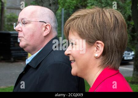 Uddingston, Scozia, Regno Unito. Nella foto: (A destra) Nicola Sturgeon - primo ministro della Scozia e leader del Partito nazionale scozzese (SNP), visto con il marito, (a sinistra) Peter Murrell CEO del Partito nazionale scozzese (SNP), Visita al suo seggio elettorale locale per esprimere il suo voto alle elezioni europee per la SNP per mantenere la Scozia in Europa. Credit: Colin Fisher/Alamy Live News. Foto Stock