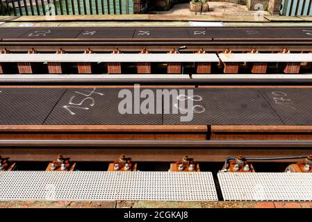 Binari sul ponte ferroviario sopra il fiume, viti di fissaggio visibili e traversine metalliche. Foto Stock