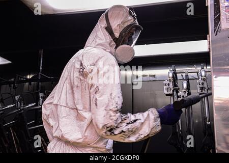 Mechanic grind auto parte per la verniciatura. Auto lavoro del corpo auto vernice di riparazione dopo incidente Foto Stock