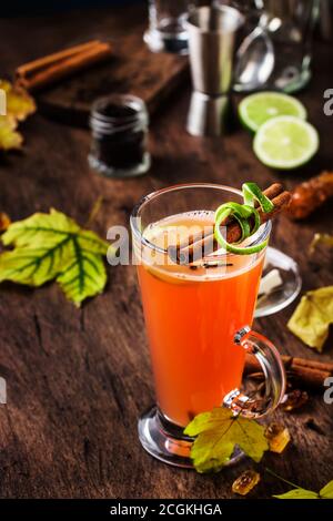 Rum caldo al burro, cocktail alcolico caldo autunno o inverno con succo di mela e limone, rum scuro, miele, cannella in calice alto su fondo scuro Foto Stock