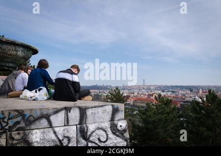 Un gruppo di giovani che chiacchierano e bevono in un punto di vista nella parte alta di Praga, Repubblica Ceca Foto Stock