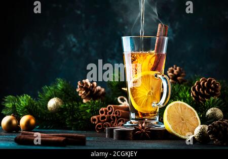 Bevanda calda invernale di Natale o Capodanno, cocktail di grog piccante, sangria o VIN brulé con tè, limone, rum, cannella, anice. Stile rustico, spazio copia Foto Stock