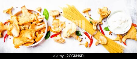 Ingredienti per cucinare la pasta con i finferli di funghi in una salsa cremosa, sfondo del cibo, vista dall'alto Foto Stock