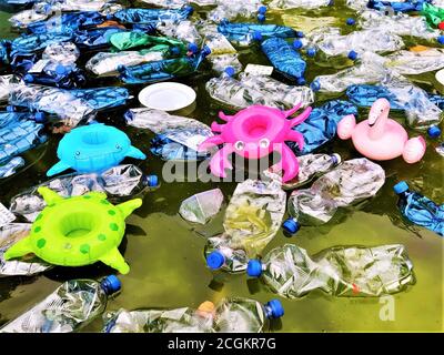 inquinamento dell'ambiente. bottiglie di plastica in acqua e giocattoli gonfiabili. Fenicotteri rosa gonfiabili, tartaruga verde, pesce azzurro, gamberi di lamponi am Foto Stock