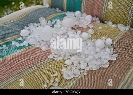 Grandi pietre di grandine accumulate su mobili da giardino dopo una grave tempesta di grandine colpito, il tempo peggiorato dal cambiamento climatico, Browntown, Wisconsin, USA Foto Stock