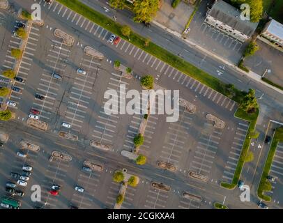 Vista aerea un gran numero di auto di marchi diversi in piedi parcheggio vicino al centro commerciale in parcheggio diviso strisce divisorie bianche e marciapiedi Foto Stock