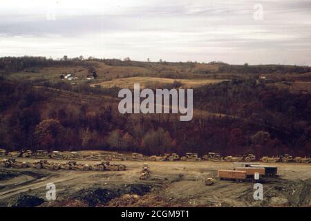 Una stringa di carrelli minerari, con una fattoria di lavoro in background. Tutta questa zona è essendo strippato dall'Ohio Power Company, Off Route 146. 10/1973 - Freeland, Muskingum County, Ohio Foto Stock