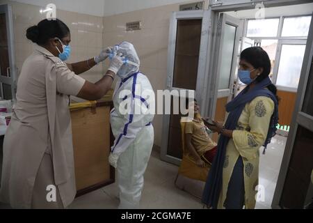 Un operatore sanitario con tuta protettiva raccoglie il campione di tampone nasale per il test rapido dell'antigene Covid-19 presso un centro di test. L'India ha registrato 4,562,414 casi confermati e 76,271 decessi per la malattia del coronavirus. Foto Stock