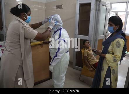 Un operatore sanitario con tuta protettiva raccoglie il campione di tampone nasale per il test rapido dell'antigene Covid-19 presso un centro di test. L'India ha registrato 4,562,414 casi confermati e 76,271 decessi per la malattia del coronavirus. Foto Stock