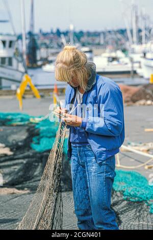 Donna che minaccia reti da pesca commerciali al Fisherman’s Terminal, Seattle, Washington USA Foto Stock