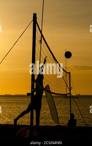 Sagome da Beach volley al tramonto giallo Foto Stock