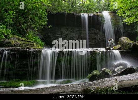 Madre e Son stanno davanti alle cascate erbose mentre backpacking Foto Stock