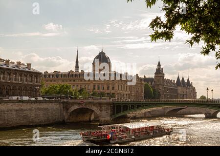 Parigi, Francia, 06/13/2010: Una giornata di sole a Parigi. Foto caratteristiche il fiume Senna con una barca turistica in esso, Pont Notre Dame, edificio Conciergerie, Foto Stock