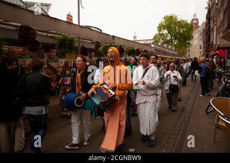 Amsterdam, Olanda 05/15/2010: Una comunità religiosa locale sta facendo una parata. I membri indossano abiti e suonano strumenti musicali mentre si divertono Foto Stock