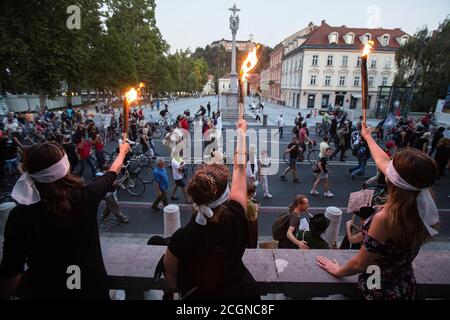 Lubiana, Slovenia. 11 Settembre 2020. I manifestanti bendati tengono le torce durante una protesta anti-governativa.per il 21° venerdì consecutivo, migliaia di persone a Lubiana hanno protestato contro il governo del primo ministro Janez Jansa tra i continui rapporti sulla sua corruzione e le prove del comportamento autoritario di Jansa. Credit: SOPA Images Limited/Alamy Live News Foto Stock