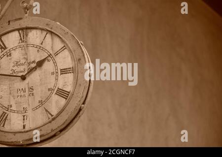 Quadrante con orologio con numeri romani d'aspetto vintage appeso alle pareti esterne, che mostra l'ora e l'arredamento in stile antico del quadrante dell'orologio. Foto Stock