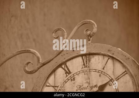 Quadrante con orologio con numeri romani d'aspetto vintage appeso alle pareti esterne, che mostra l'ora e l'arredamento in stile antico del quadrante dell'orologio. Foto Stock
