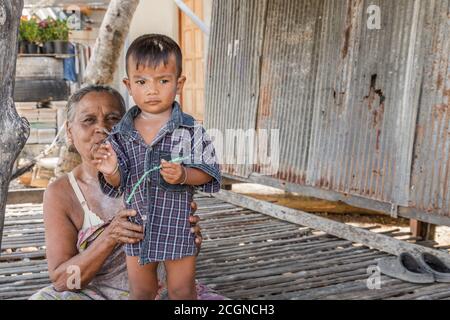 Una nonna e suo nipote che riposano su una prica in Thailandia. Foto Stock