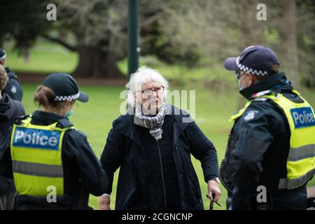 Melbourne, Australia 12 Set 2020, la polizia ha interrogato una donna anziana protetista nei Giardini Fitzroy che stava cercando di assistere a una protesta anti-maschera e anti-blocco nel parco di Melbourne Australia. Credit: Michael Currie/Alamy Live News Foto Stock