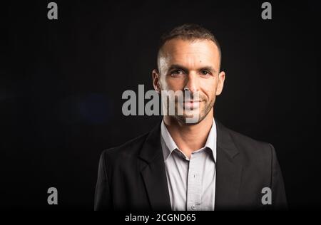 Bell'uomo sorridente. Primo piano. Sfondo nero. Foto Stock