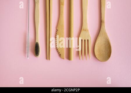 Posate eco-friendly in bambù in una custodia su sfondo rosa. Concetto di zero sprechi. Set di posate di bambù in un caso su una posa su un tavolo. Cucchiaio Foto Stock