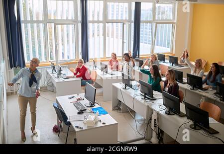Docente femminile che insegna la lezione in aula universitaria Foto Stock