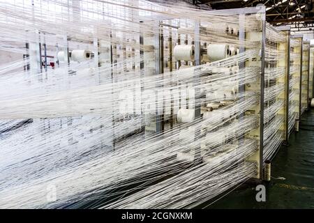 Johannesburg, Sudafrica - 16 ottobre 2012: Linee di filo di cotone per un telaio della linea di assemblaggio della trama dell'avvolgitore Foto Stock