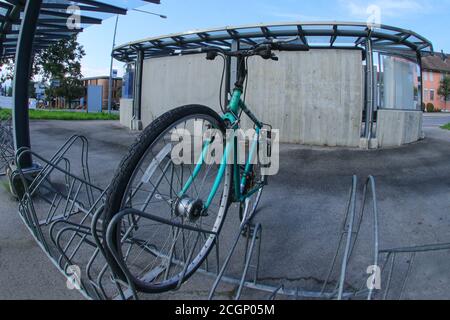 Molte biciclette nere e verdi in fila. Tendenze nel settore della produzione di biciclette. Gruppo di cicli. Parcheggio per biciclette a noleggio. Trasporti eco-compatibili Foto Stock