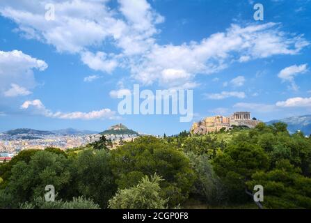 Vista della collina dell'Acropoli con Propylaea e Partenone e la collina di Lycabettus in background ad Atene, Grecia dalla collina di Pnyx in estate luce del giorno con grea Foto Stock