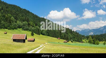 Percorso attraverso un prato con fienili al Geroldsee, vicino a Klais, alta Baviera, Baviera, Germania Foto Stock