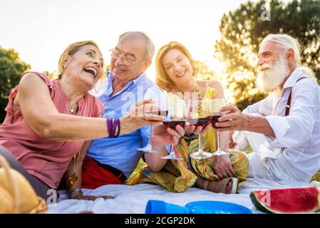 Gruppo di giovani anziani che si divertono all'aperto - quattro pensionati che si legano all'aperto, concetti di stile di vita e anziani Foto Stock