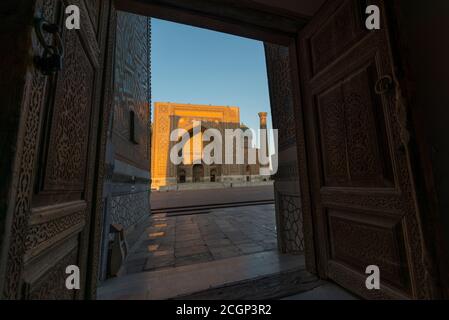 Sher-Dor Madrasah visto da Ulugh Beg Madrasah. Il Registan. Samarcanda, Uzbekistan Foto Stock