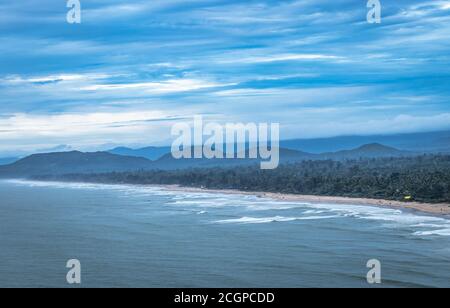 la vista sulla spiaggia dalla cima della montagna, con la catena montuosa sullo sfondo e l'incredibile immagine del cielo, viene scattata a gokarna karnataka india, che mostra l'immacolato beaut Foto Stock