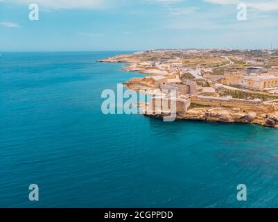 Antico forte militare in pietra Malta isola fatta di rocce di mattoni sulla riva blu mare con vista città Valetta, vista aerea dall'alto Foto Stock