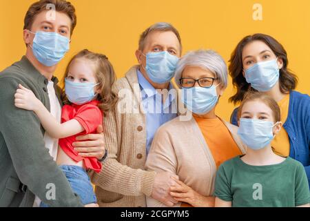 La famiglia indossa maschere facciali durante il coronavirus e l'epidemia di influenza. Protezione da virus e malattie, quarantena. COVID-2019. Assumere maschere. Persone in grido Foto Stock