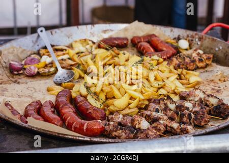 Barbecue fiera festival cibo salsiccia patate carne cucina marmite all'aperto Foto Stock