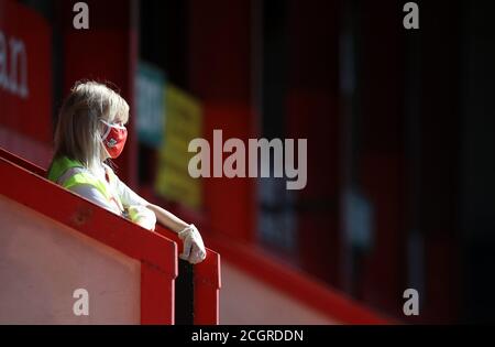 Un amministratore che indossa i DPI negli stand durante la partita Sky Bet League One a Gresty Road, Crewe. Foto Stock