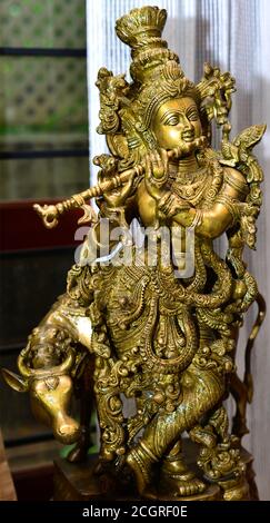 Una statua di Lord Krishna fatta a mano in ottone con Flauto e mucca. Foto Stock