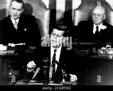 Il Presidente John F. Kennedy nel suo storico messaggio ad una sessione congiunta del Congresso, il 25 maggio 1961 ha dichiarato: "...credo che questa nazione dovrebbe impegnarsi a raggiungere l'obiettivo, prima che questo decennio sia fuori, di atterrare un uomo sulla Luna e di riportarlo in sicurezza sulla Terra". Questo obiettivo è stato raggiunto quando l'astronauta Neil A. Armstrong è diventato il primo umano a mettere piede sulla Luna alle 10:56 p.m. EDT, 20 luglio 1969. Sullo sfondo sono mostrati (a sinistra) il Vice Presidente Lyndon Johnson e (a destra) il Presidente della Casa Sam T. Rayburn. Foto Stock