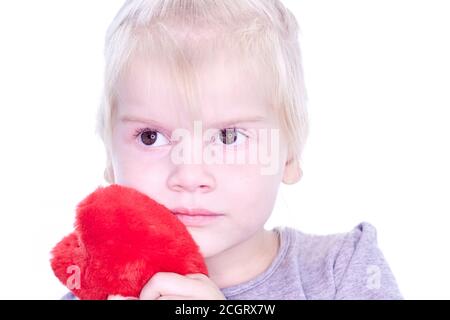 Felice bambina sorridente con grande cuore rosso di carta su sfondo bianco Foto Stock