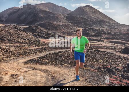 Atleta runner man che corre su percorsi all'aperto montagne paesaggio. Difficile allenamento endurance gara di maratona ultra running al sole Foto Stock