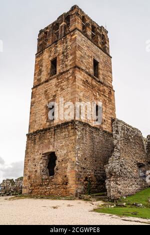 Città di Panama, Panama - 30 novembre 2008: Torre di pietra marrone di antica cattedrale in rovine al parco di Panama Viejo, contro il cielo argentato con prato verde. Foto Stock