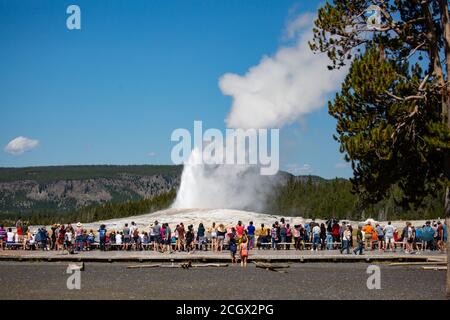 Yellowstone, Wyoming, USA, 19 agosto 2019, i turisti si riuniscono intorno per guardare l'eruzione di Old Faithful Giser, orizzontale Foto Stock