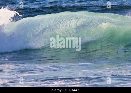 Bella rottura onda acquamarina coperto da frothy whitecap. Foto Stock