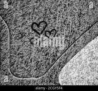 Tre cuori attirati su finestra grime strato di grigio secco fango Foto Stock