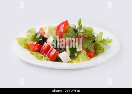 Insalata greca sulla piastra bianca e lo sfondo grigio Foto Stock
