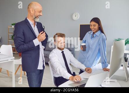 Lavoratori aziendali positivi che parlano, ridono, si godono la conversazione durante la pausa caffè al lavoro Foto Stock