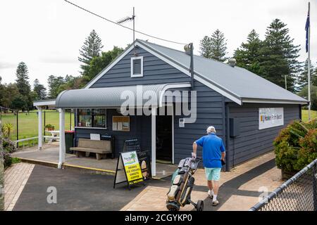Uomo australiano che tira la sua borsa da golf e il trolley al campo da golf pubblico di Palm Beach a Sydney, Australia Foto Stock