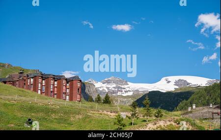 Condominio in stile alpino con facciata in legno circondato da località sciistiche e vista sulle montagne. Foto Stock